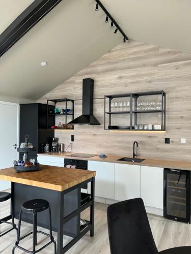 a kitchen with white cabinets and a wooden wall at Reine City Apartment in Reine