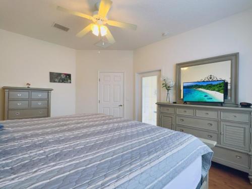 - une chambre avec un lit et une télévision à écran plat dans l'établissement Fantastic 4 BR Home With Private Pool & Spa 137MH villa, à Haines City