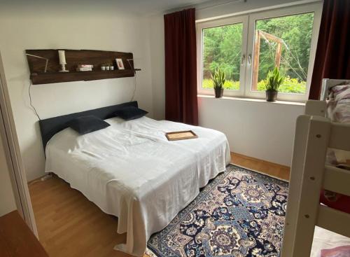 a bedroom with a white bed and a window at Haus Wiesengrund in Winterberg