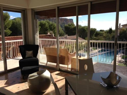 a living room with a table and a view of a pool at Villa W in Cassis