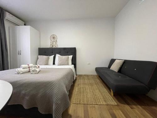 a bedroom with a bed and a couch at Central Studio Apartments in Tirana
