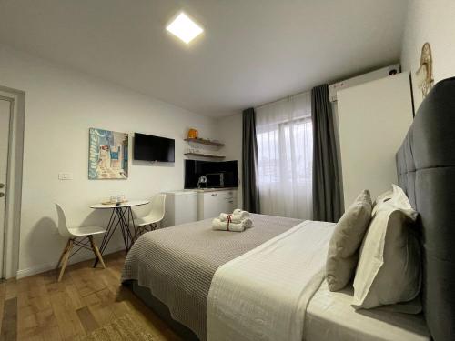 a hotel room with a bed and a table and a kitchen at Central Studio Apartments in Tirana