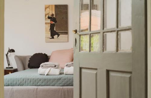 una puerta que conduce a una habitación con una cama y una foto de un hombre en Zamatos Turbolya Kisház és Wellness, en Pannonhalma