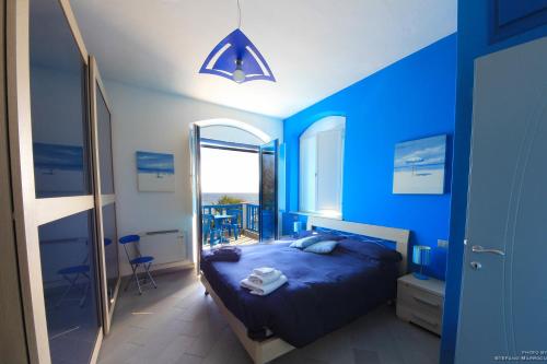 a blue bedroom with a bed and a mirror at La Casa Sulla Spiaggia in Flumini di Quartu