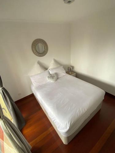 a bed in a room with a white bedsheet at Por do Sol in Caniço