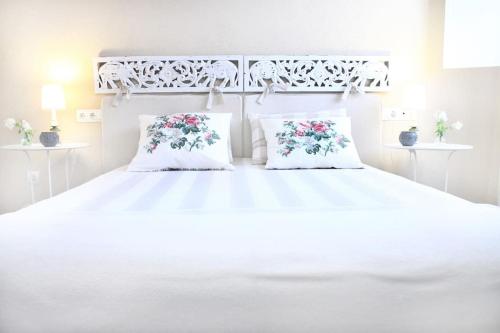 a bedroom with a white bed with two pillows at La Casita de Teresa in Córdoba