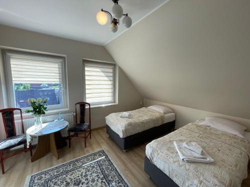 sypialnia z 2 łóżkami, stołem i oknem w obiekcie Hotel Janta w mieście Dziemiany