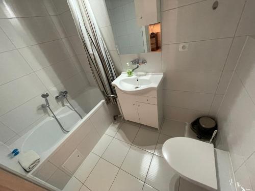 uma casa de banho branca com um lavatório, uma banheira e um WC. em Hotel Janta em Dziemiany