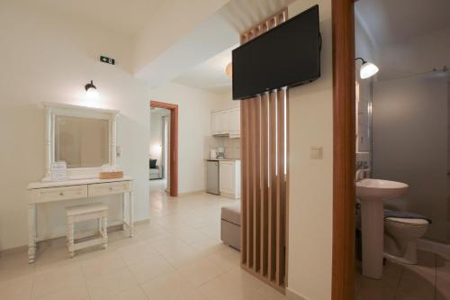 a bathroom with a television on a wall with a sink at Philharmonie Hotel in Kalamaki Heraklion