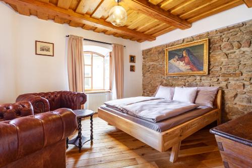 a bedroom with a bed and a stone wall at Apartments No 126 Loket in Loket