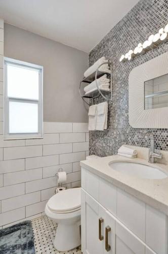 a white bathroom with a toilet and a sink at Unique Las Olas Stay Pool Free Parking in Fort Lauderdale