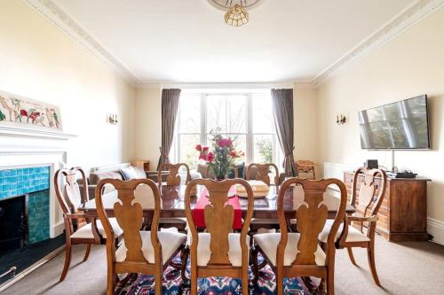 a dining room with a table and chairs and a fireplace at Perfect Family & Friends Home, Free Parking Security Onsite in Reading