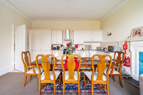 a dining room with a table and chairs and a kitchen at Perfect for Large Family & Friends, Free Parking, Games in Reading