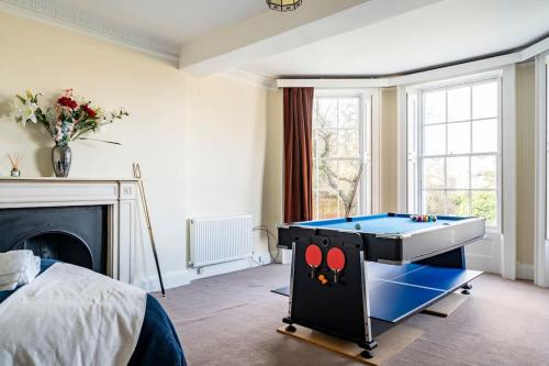 a bedroom with a pool table in front of a fireplace at Perfect for Large Family & Friends, Free Parking, Games in Reading
