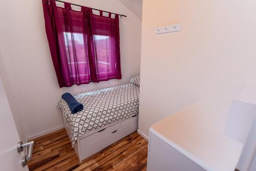 a small room with a bed and a window at Holiday House Mablo with pool & jacuzzi in Šibenik