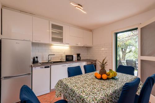 a kitchen with a table with a bowl of fruit on it at Holiday House Mablo with pool & jacuzzi in Šibenik