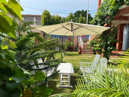a table and chairs and an umbrella in a yard at Holiday Appartment Elbe in Lomé