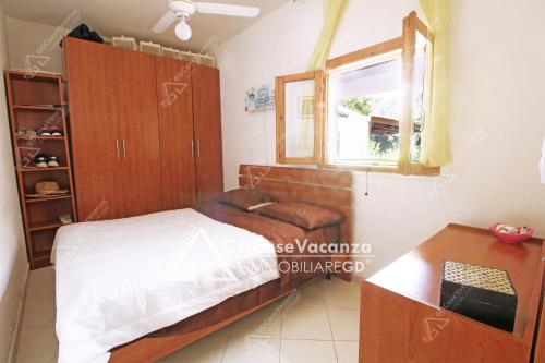 1 dormitorio con cama y ventana en GD Case Vacanza - Villetta Palegano -, en Fontanelle