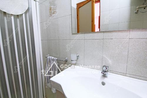 ein Badezimmer mit einem weißen Waschbecken und einem Spiegel in der Unterkunft GD Case Vacanza - Villetta Palegano - in Fontanelle