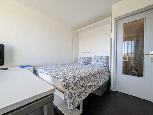 une petite chambre avec un lit et une fenêtre dans l'établissement Studio Héliopolis K Int. Village Natu, Clim, Park., au Cap d'Agde