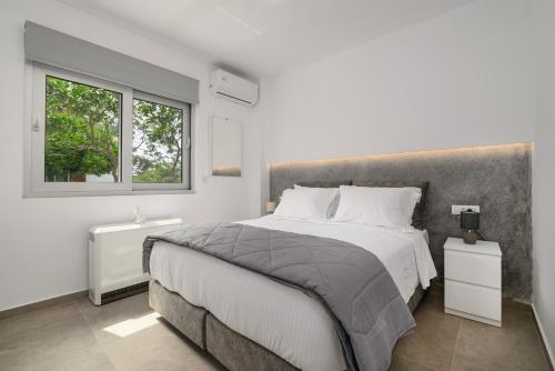 a bedroom with a large bed and a window at Aetherius Executive Suite 5 Min to BEACH in Kos Town