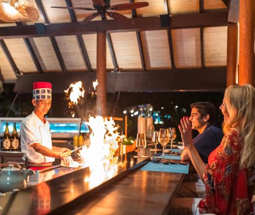 a group of people sitting at a bar at Fushifaru Maldives with 50 percent off on sea plane roundtrip 04 nights & above in Fushifaru