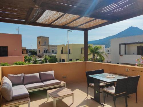 d'une terrasse avec un canapé et une table sur un balcon. dans l'établissement Villa Favignana, à Favignana