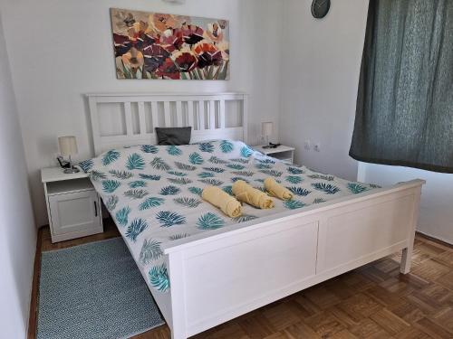 ein Schlafzimmer mit einem weißen Bett mit einer blauen und weißen Bettdecke in der Unterkunft Apartment Drazica in Opatija