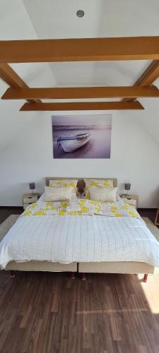 a bedroom with a bed with a painting on the wall at Lille hygge in Leck