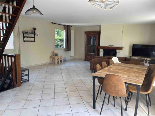 un salon avec une table et des chaises en bois dans l'établissement Maison familiale à Nanterre - Paris, à Nanterre