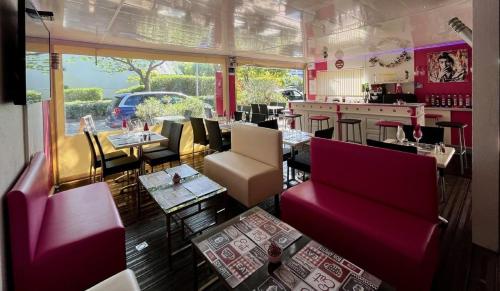 un restaurant avec des chaises et des tables rouges ainsi qu'un bar dans l'établissement Vittoria Immobilier 2 -REGLEMENT SUR PLACE - chèques vacances acceptés, à La Grande Motte