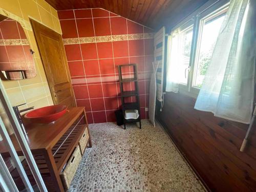 een badkamer met een wastafel en een rode tegelmuur bij Maison familiale à Nanterre - Paris in Nanterre