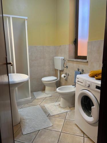 a bathroom with a washing machine and a toilet at Delfino House in Terrasini