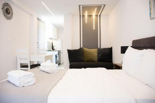 um quarto branco com uma cama e um sofá em SKG Dream Residence em Tessalônica