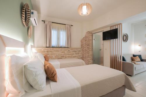 a bedroom with two beds and a living room at Philharmonie Hotel in Kalamaki