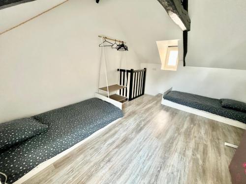 een kamer met 2 bedden en een trap bij Charmante maison au coeur de Villerville in Villerville