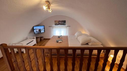una camera mansardata con letto e cuscini sopra di Villa Sertis Santorini a Imerovigli