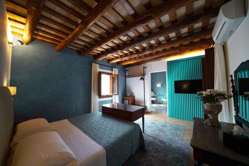 a bedroom with a bed and a table in a room at Hotel Carmine in Marsala