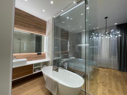 a bathroom with a tub and a sink and a bed at Doroshenka Premium Apartments in Lviv