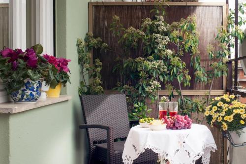uma mesa com uma toalha de mesa branca e flores num pátio em Roma-Incantata Apartment em Roma
