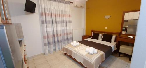 a bedroom with a bed and a desk and a television at Anna Rooms in Ierissos