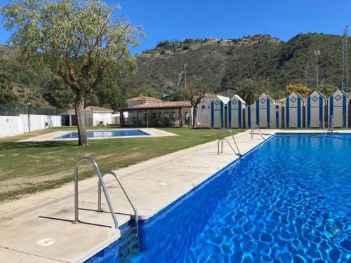 ein Schwimmbad mit blauem Wasser in einem Park in der Unterkunft Duplex temático Andaluz con agradable terraza - El Mirador de Benahavis 2 in Benahavís