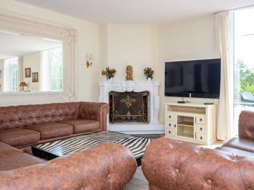 a living room with leather furniture and a television at 26 person holiday home in Lunderskov in Lunderskov