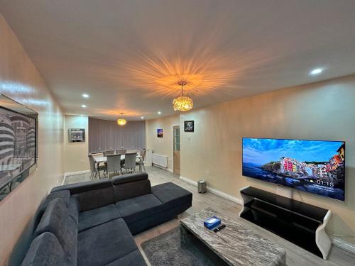 a living room with a couch and a flat screen tv at Full Home in Heywood Street near Cheetham Hill in Manchester