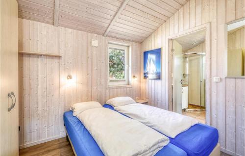 ein großes Bett in einem Zimmer mit Holzwänden in der Unterkunft Schatzkiste 9 - Dorf 4 in Travemünde
