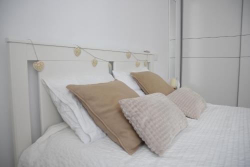 ein Bett mit weißer Bettwäsche und Kissen darauf in der Unterkunft Nuevo apartamento en Santander! in Santander