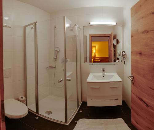 a bathroom with a shower and a sink at Hotel Habicht in Fulpmes