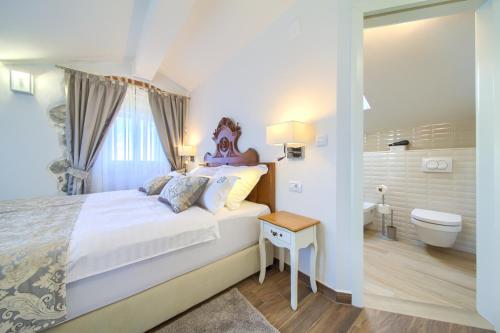 a bedroom with a bed and a bathroom with a toilet at Luxury Villa Ive With Heated Pool, Finnish Sauna, Infrared Sauna, Pet Friendly in Krk