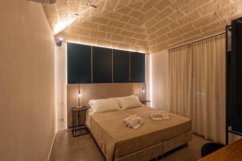 1 dormitorio con 1 cama con 2 toallas en Mazzini Accommodation, en Favignana
