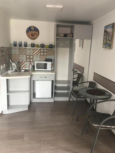 eine kleine Küche mit einem Tisch und einer Mikrowelle in der Unterkunft Апартаменты в Старом городе in Kamjanez-Podilskyj